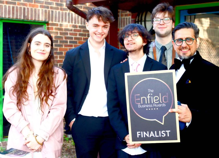 Garry Kousoulou with young people holding an Enfield Business Awards finalist sign